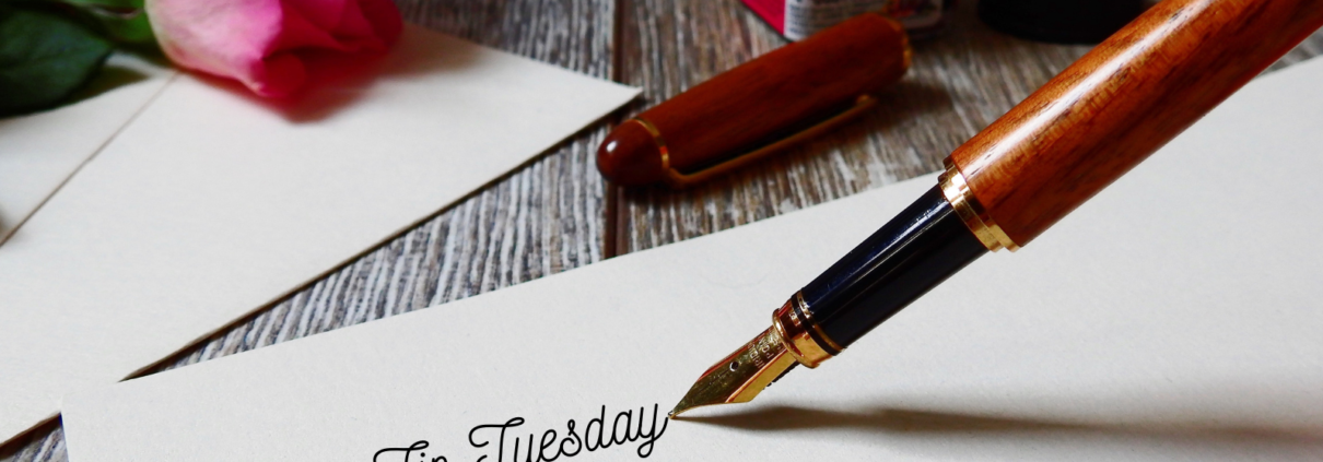 Old-style ink pen writing "Tip Tuesday" on paper