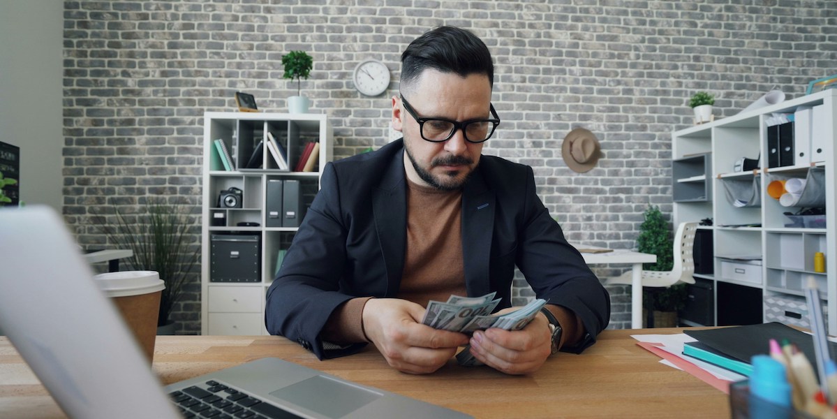 CFO counting money representing how ghostwriting is the means to profitability